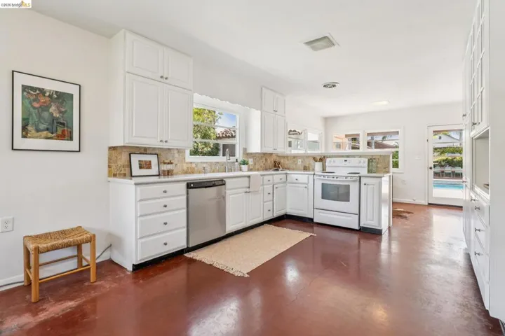 Kitchen featuring white cabinetry, stone-finish countertops, stainless steel dishwasher, and a white electric range