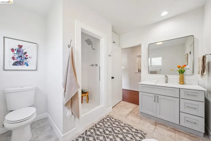 Contemporary bathroom featuring a light gray vanity with a white countertop, a rectangular undermount sink, and a modern wall mirror