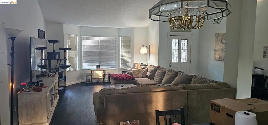 Living area featuring dark wood-finish flooring and a vaulted ceiling