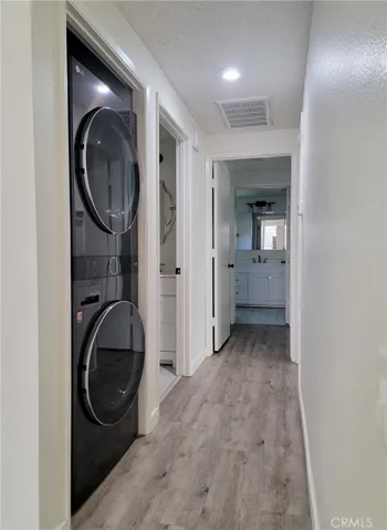 Hallway with LG full size stack laundry.