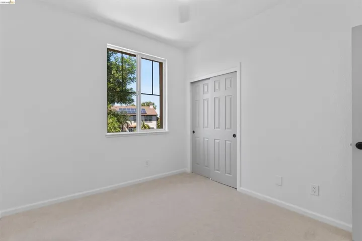 Neutral tone wall finishes, carpeting, and a window with exterior views