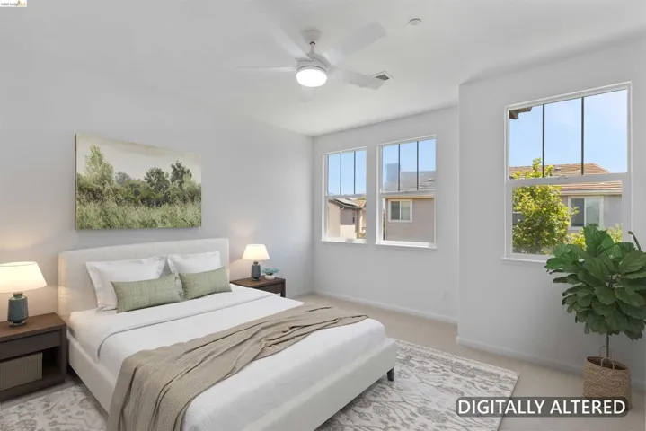 Bedroom featuring a ceiling fan, three paneled windows, and neutral carpeting