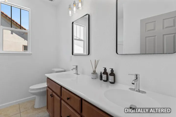 Bathroom featuring a double vanity with wood-finish cabinetry, white countertops, two integrated sinks, and polished chrome faucets