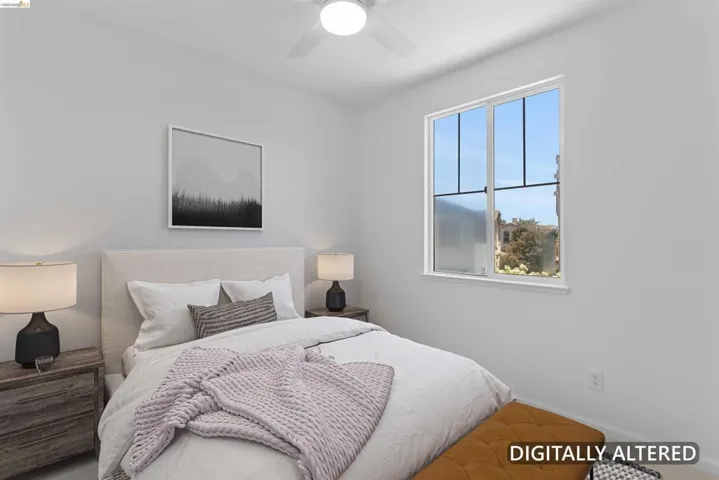 Bright room featuring a large window, a ceiling fan, and light-colored walls