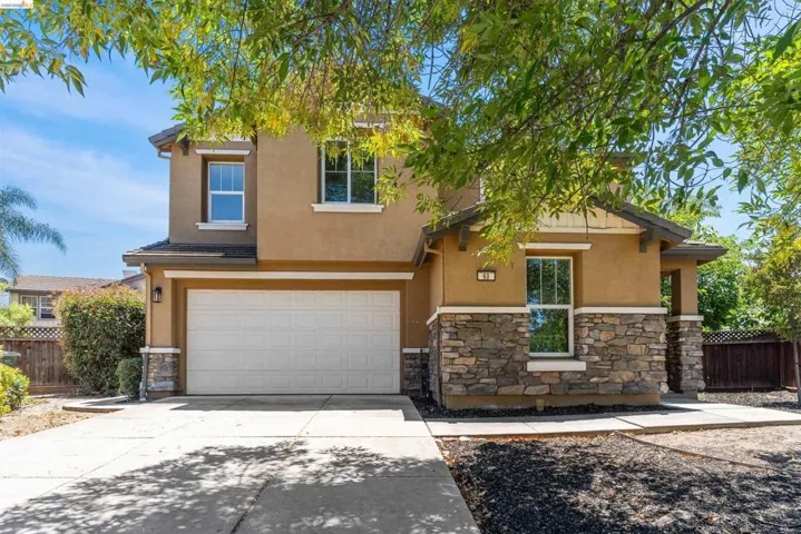 Stucco exterior featuring a stacked stone facade and a two-car garage