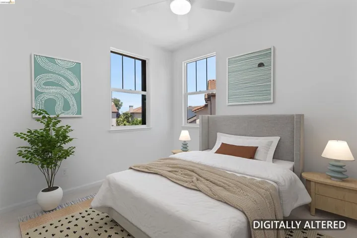 Bright bedroom featuring two large windows, a ceiling fan, and carpeted flooring