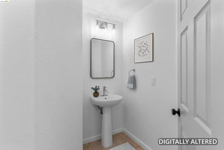 Pedestal sink with chrome fixtures and a rectangular mirror