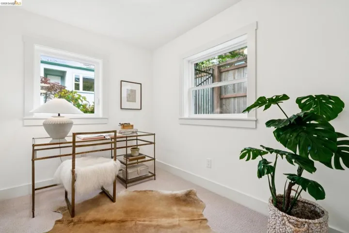 Room featuring two windows with white trim, light-colored carpet, and white walls