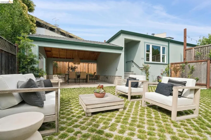Landscaped backyard featuring permeable pavers with grass inserts and a covered patio