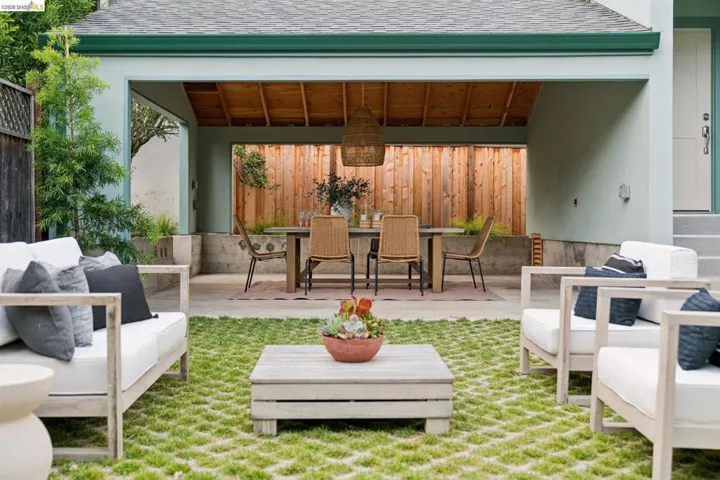 Covered patio area featuring a slatted wood ceiling, concrete floor, and a built-in privacy fence
