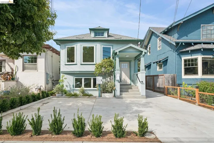 Two-story residence with a light blue exterior and white trim, featuring a dormer window