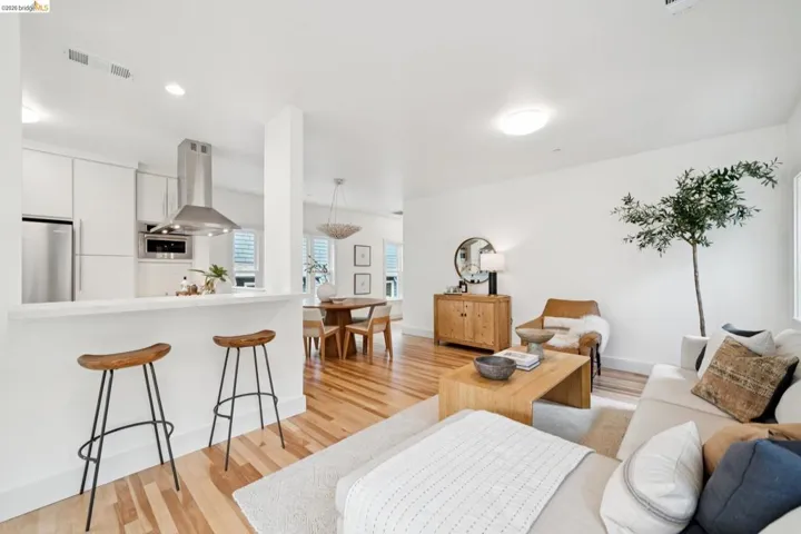 Open-concept living space featuring wood-finish flooring, recessed lighting, and white walls