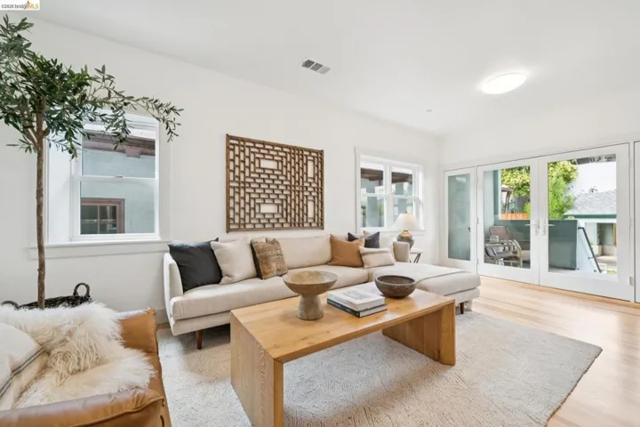 Bright living area featuring light wood-finish flooring, white walls, and recessed lighting