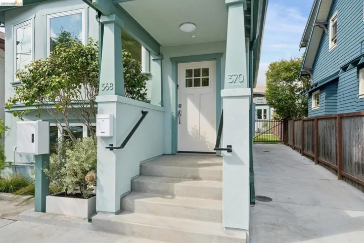 Light blue exterior with white trim, featuring a white paneled front door with upper window panes