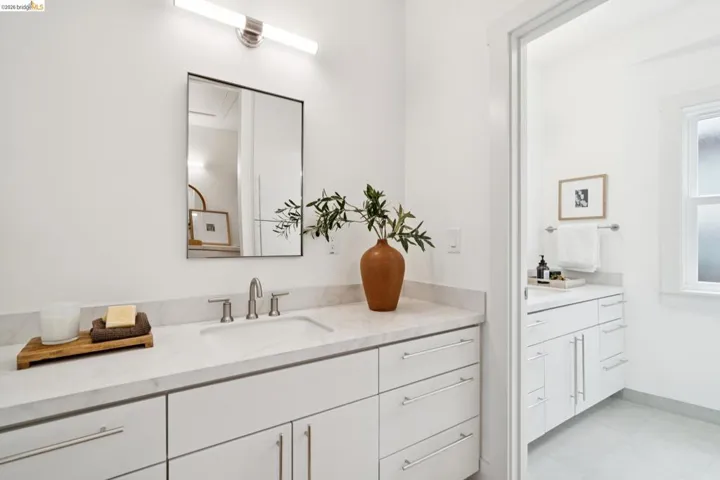 Bathroom vanity with a white countertop, undermount sink, and brushed nickel faucet
