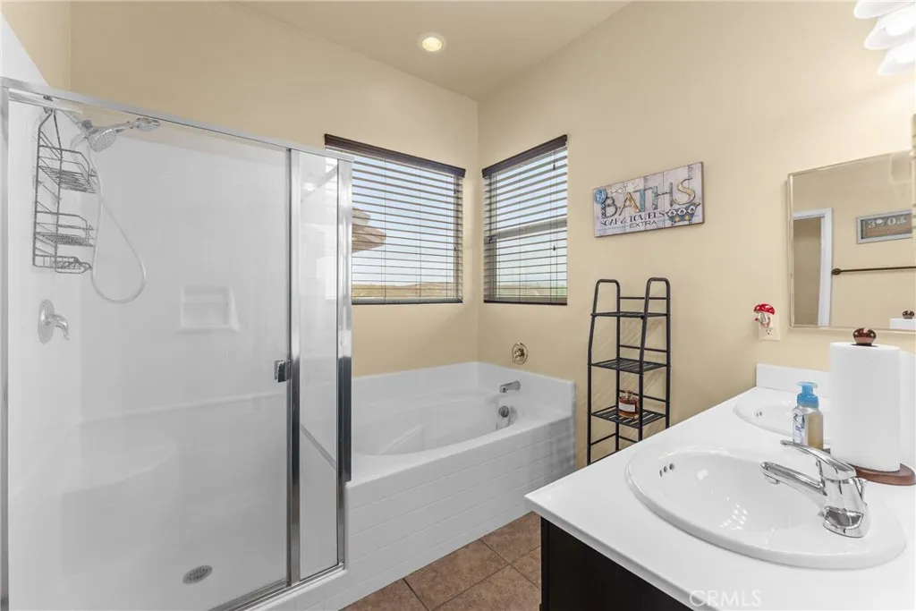 The primary en suite bathroom offers a double sink vanity and a shower/tub setup.