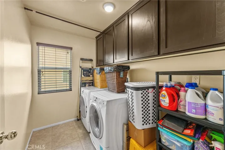 Upstairs laundry room complete with ample custom cabinetry.