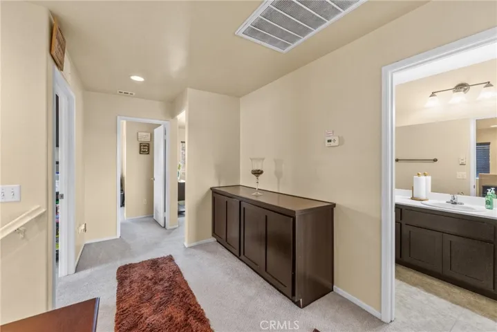 Spacious second-floor landing featuring custom built-in cabinetry for extra storage.