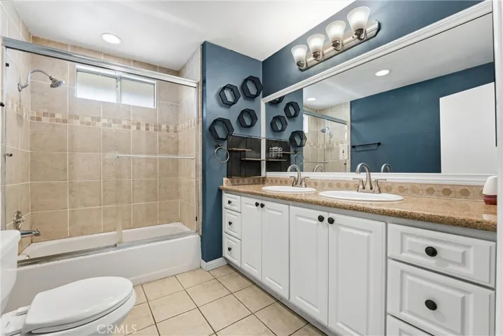 Open upstairs bathroom with dual sinks, tub, and shower and many cabinets for storage