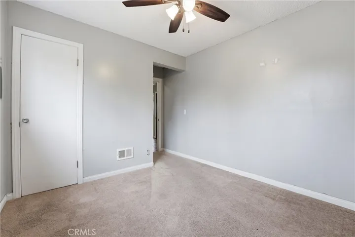 Another view of bedroom with closet space and fan for ventilation