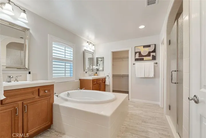 Primary bathroom with two walk-in closets, large shower, really large soaking tub and dual vanities