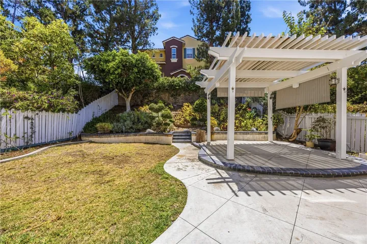 Private and cozy backyard with a lovely white pergola, perfect for relaxation and BBQ