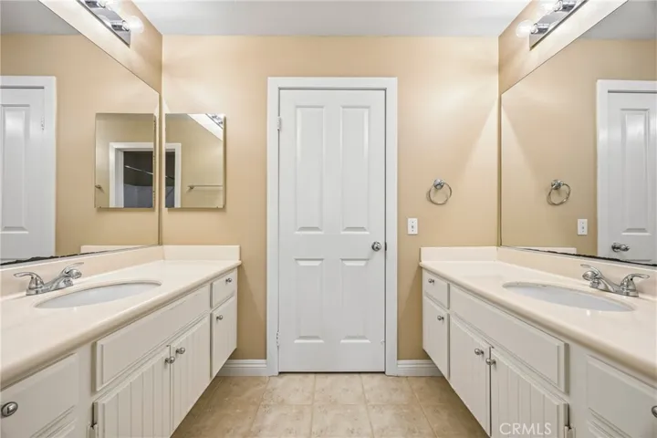 Convenient full bath shared by two bedrooms featuring separate dual vanities