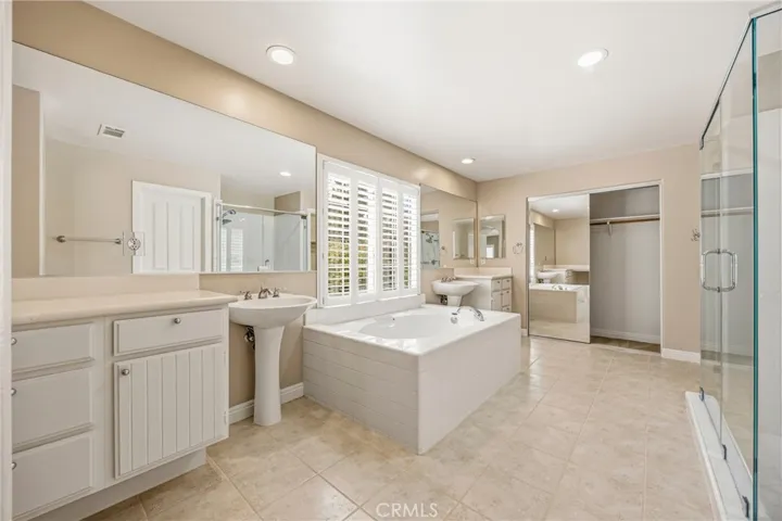 Spacious master bathroom with dual vanities and seamless access to the walk-in closet