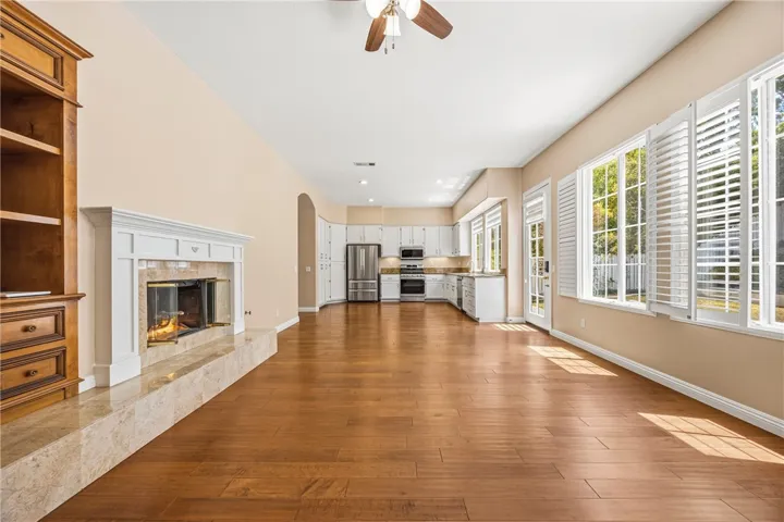 Open-concept family room with a cozy fireplace, leading into the dining area and kitchen