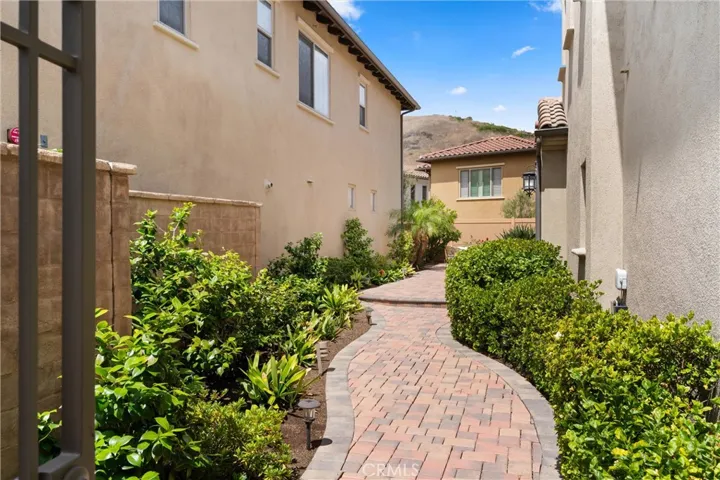 Private paver walkway with landscaped planting beds creating a welcoming approach to the courtyard and entry.