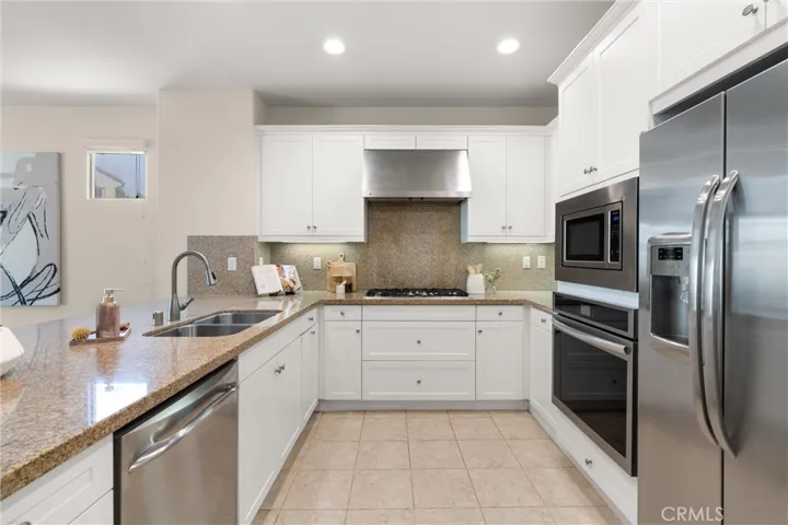 Kitchen featuring shaker style cabinetry, granite countertops, stainless steel appliances, recessed lighting, and ample prep space.