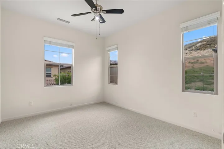 Secondary bedroom featuring multiple windows, recessed lighting, and abundant natural light.