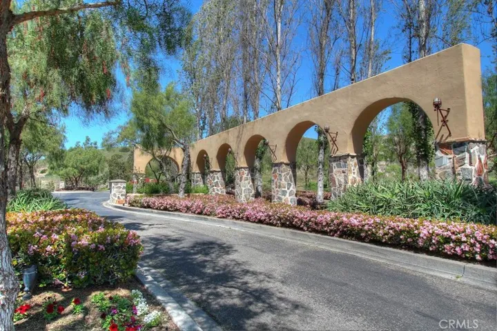 Architectural community entry with lush landscaping and distinctive character