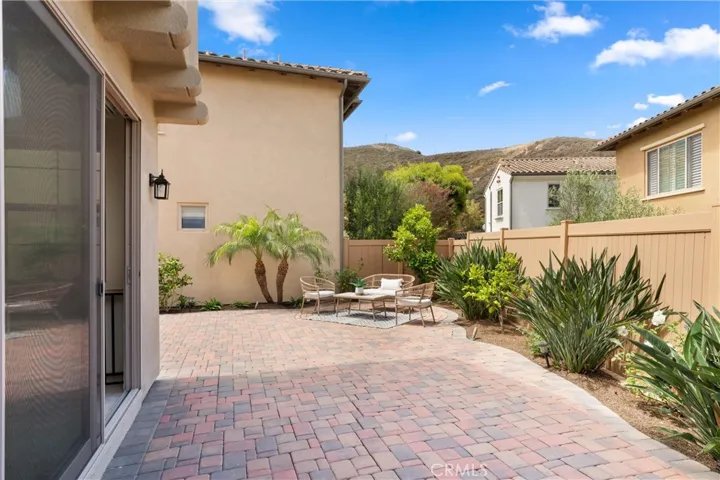 Private backyard with paver hardscape, landscaped planting beds, and flexible outdoor seating space.
