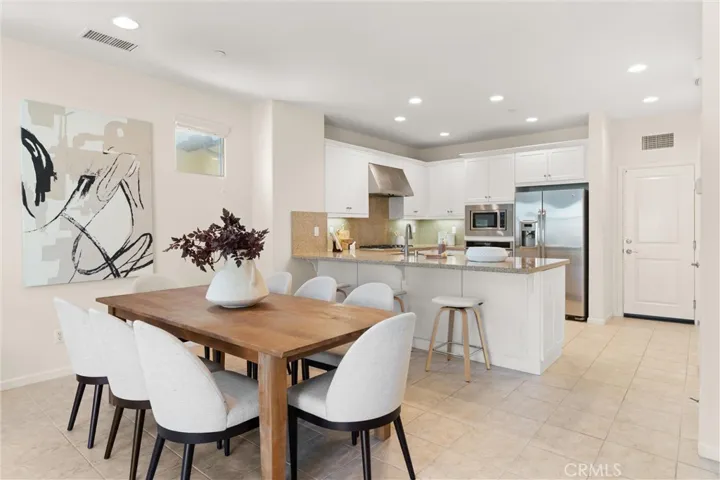Dining area adjacent to the kitchen with breakfast bar seating and open concept design.