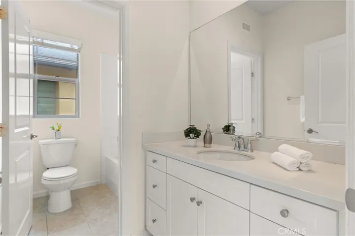 Secondary bathroom featuring a spacious vanity with ample counter space and storage.