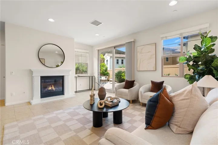 Living room with fireplace, large windows, and sliding glass doors creating an open and airy feel.
