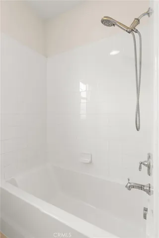 Secondary bathroom with tub and shower combination and clean, timeless finishes.