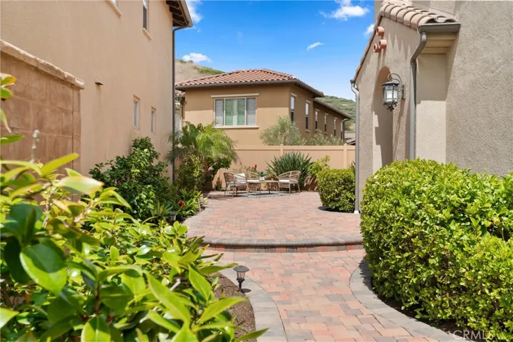 Courtyard space with paver hardscape, mature landscaping, and an area suitable for outdoor seating and entertaining.