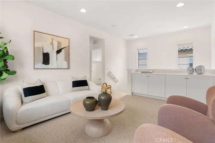 Upper level loft featuring built in storage cabinetry, recessed lighting, and flexible living space.