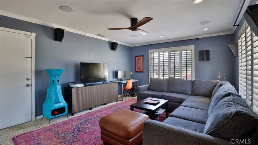 The family room has carpet, ceiling fan, can lighting, large windows with plantation shutters, wired for surround sound and access to the garage.