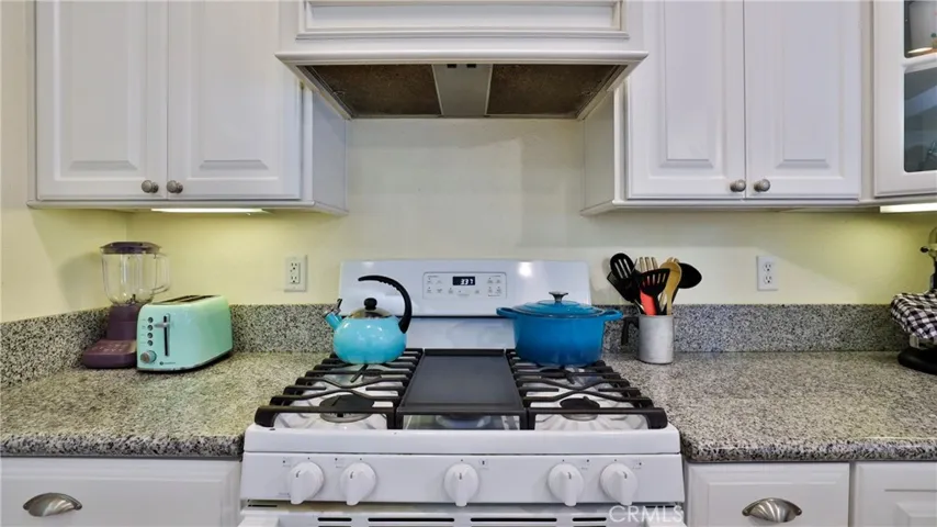 The stove is a 5 burner gas stove with hood vent above