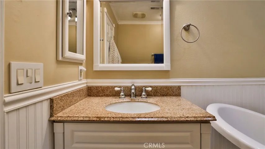 Primary bathroom features, vanity, medicine cabinet, wainscoating