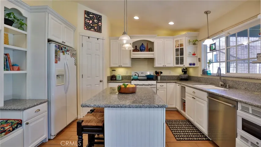 Lots of built-ins so there is plenty of storage. The refrigerator stays, there is a walk in pantry, Island with breakfast bar, storage underneath and pendant lighting. Bosch dishwasher.