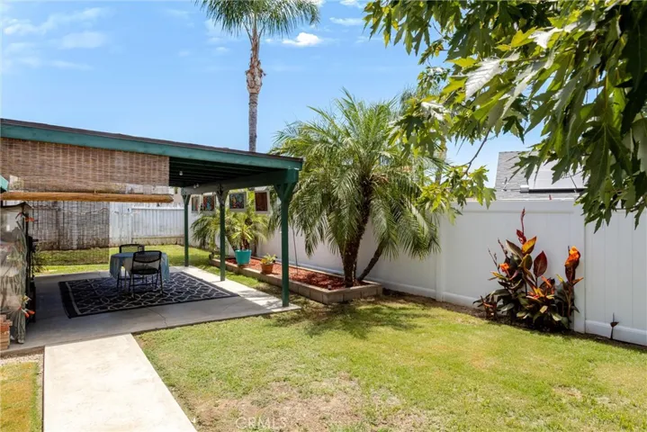 View from backyard facing East showing patio, palms and plants