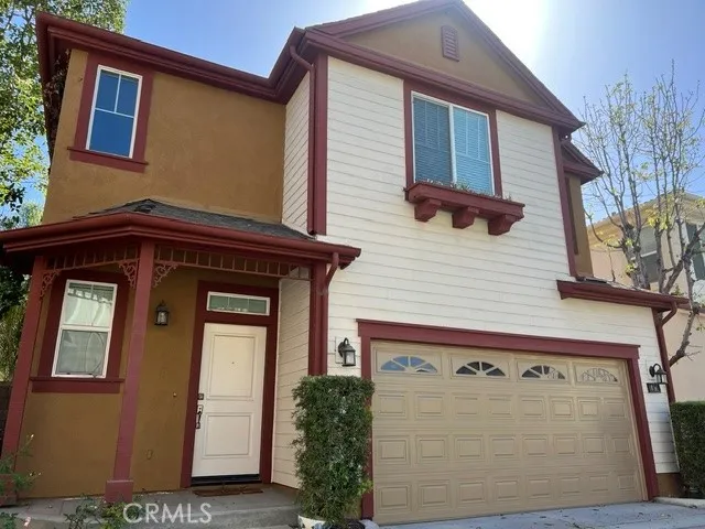 Well-maintained two-story single-family residence with a stucco exterior, tile roof, and attached two-car garage. The home features a covered front entry, attractive architectural accents, and low-maintenance landscaping. Overall curb appeal is good, with exterior finishes appearing to be in average to good condition based on the available photograph.