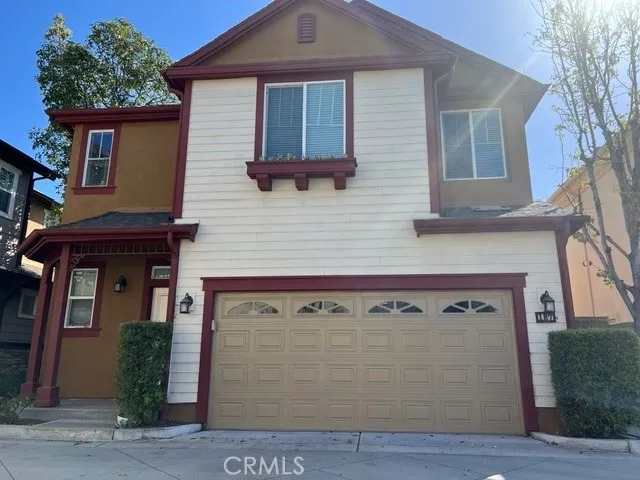Charming two-story single-family residence featuring attractive Spanish-inspired architecture with a warm stucco exterior and decorative shutters. The home offers excellent curb appeal with a welcoming front entry, a spacious two-car attached garage, and a well-maintained driveway. Architectural accents, including arched details and contrasting trim, enhance the home's character and create an inviting streetscape presence. The low-maintenance front landscaping complements the exterior design while provid...