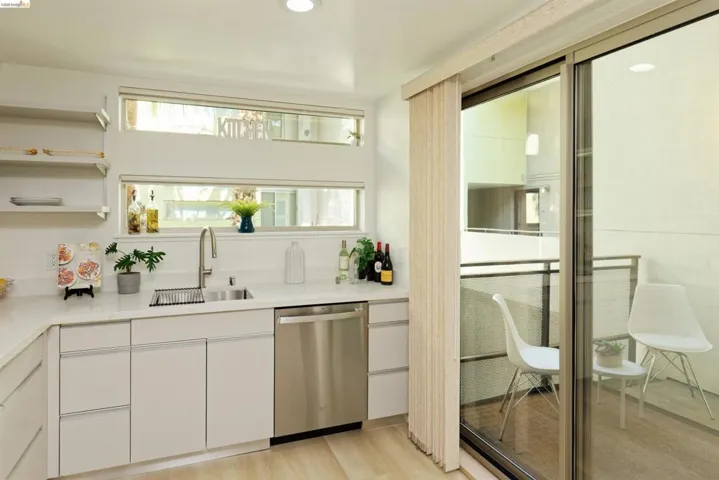 Bar area with white cabinets, stainless steel dishwasher, light wood finished floors, recessed lighting, and modern cabinets