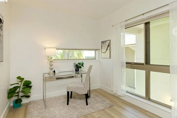Home office with light wood-style flooring and baseboards