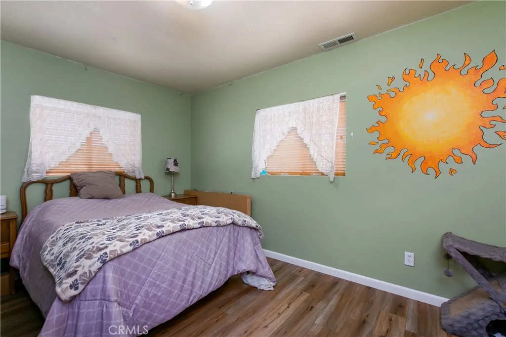 The inviting second bedroom located upstairs right next to the hallway bathroom. This versatile room features a clean neutral color palette, white baseboards, and a large window with blinds that fills the space with great natural light, making it a perfect kid's room, guest room, or home office.